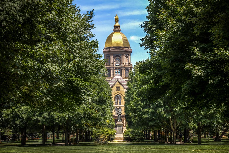 Contact - Gold Dome on the Campus of Notre Dame in South Bend Indiana, Seen Between Tall Leafy Trees